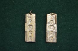 A pair of silver ingot pendants.