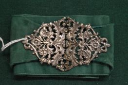 A silver nurses belt buckle and belt.