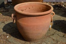 A large terracotta plant pot with ring handles.