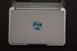 A cushion shaped blue topaz, boxed with certificate.
