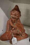 Moulded terracotta figure of a man playing a tambourine.
