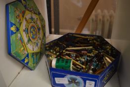 A tin of lace bobbins.