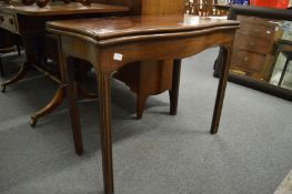 A George III mahogany fold-over tea table of serpentine outline on moulded square legs.