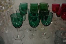 Twelve green glass wine glasses.