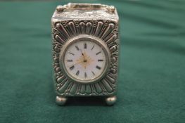 A good small embossed silver and enamel carriage clock.