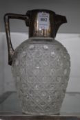 A cut glass and silver mounted claret jug and a silver photograph frame.