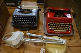 Two typewriters and a desk magnifying lamp.