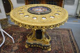 A highly ornate ormolu circular centre table inset with sevres style porcelain portrait panels.