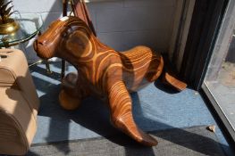An unusual large carved laminated wood sculpture of a sea lion with a ball under one flipper.