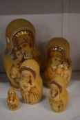 A set of five Russian wooden dolls with poker work and gilded decoration.