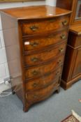 A walnut bow fronted six drawer chest.