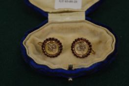 A pair of decorative earrings with screw thread fittings.