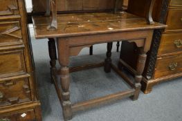 An 18th/19th century oak occasional table with plank top on turned and stretchered supports.