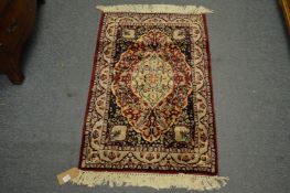 A small Persian design rug, red ground with floral decoration, 93cm x 61cm.