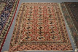 An old Bokhara rug, rust ground with three rows of 9 medallions, 167cm x 127cm.