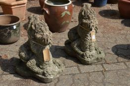 A pair of reconstituted stone garden ornaments modelled as dragons.