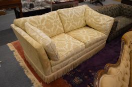 A large two seater settee with classical style upholstery.