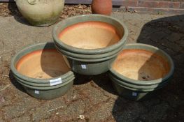 Three large green glazed circular plant pots.