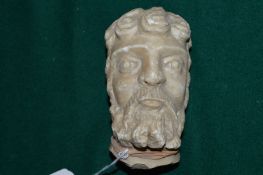 A carved alabaster head of a bearded man.