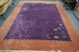 A Chinese carpet, plum ground decorated with vases and urns of flowers within a rust ground