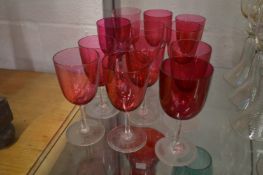 Twelve cranberry wine glasses.