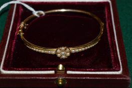 A 15ct gold and seed pearl bangle.