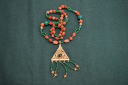 A carnelian and jade necklace with decorative pendant.