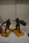 A pair of cast metal models of warriors on marble bases.
