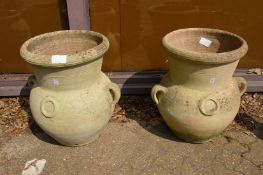 A large pair of pottery urns or planters.