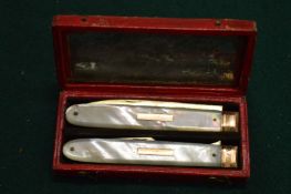 A good silver gilt and mother of pearl fruit knife and fork, in fitted leather case.