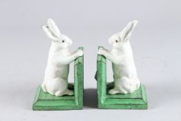 A PAIR OF SMALL PAINTED CAST IRON RABBIT BOOKENDS. 5.5ins high.