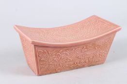 A CHINESE PINK PORCELAIN PILLOW. 8.5ins long.