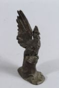 A SMALL BRONZE COCKEREL on a rustic base. Signed. 6.5ins high.