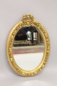 A LOUIS XVI STYLE GILTWOOD OVAL MIRROR.