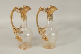 A GOOD PAIR OF ART DECO ENGRAVED GLASS AND GILT METAL CLARET JUGS, engraved with flowers. 31cms