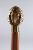 A WALKING STICK WITH FOUR-SIDED MAN HANDLE.