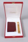 A CARTIER WRITING SET, two pens and a card case, in a Cartier box.