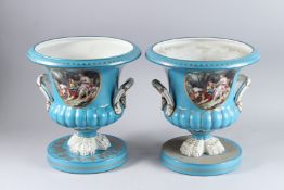 A LARGE PAIR OF SEVRES DESIGN BLUE GROUND TWO-HANDLED URNS with panels of figures, on circular