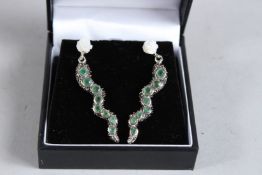 A PAIR OF SILVER AND EMERALD SET SNAKE EARRINGS.