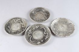 FOUR CHINESE WHITE METAL CIRCULAR COIN DISHES. 3.75ins.