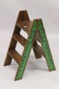 A CHAMPAGNE WOODEN FOLDING LADDER. 2ft 10ins high.