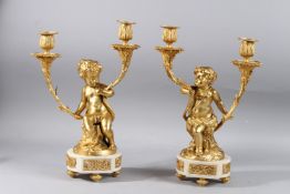 AFTER CLODION. A VERY GOOD PAIR OF TWO LIGHT CUPID CANDELABRA formed as a cupid holding scrolling