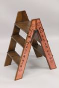 A CHAMPAGNE WOODEN FOLDING LADDER. 2ft 10ins high.