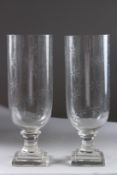 A PAIR OF CUT GLASS HURRICANE LAMPS on square stem bases. 13ins high.