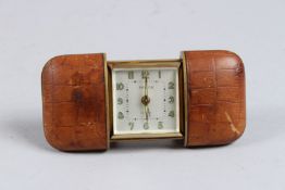 A SENECA LEATHER-BOUND FOLDING TRAVELLING CLOCK.