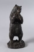 A BRONZE STANDING BEAR with grapes. 11ins high.
