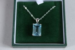 A SILVER AND EMERALD CUT BLUE TOPAZ NECKLACE.