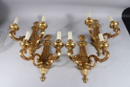 A GOOD SET OF FOUR LOUIS XVITH DESIGN GILT METAL TWO BRANCH WALL LIGHTS. 13ins long.
