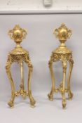 A LARGE PAIR OF LOUIS XVI GILTWOOD TWO-HANDLED URNS ON STANDS, the urns carved with panels of roses,