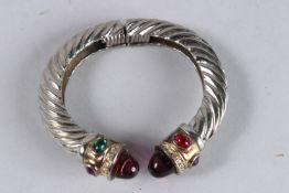 A SILVER BANGLE with blue stones.